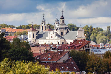 Litauen, Vilnius, Gewitterwolken über Kirche und Wohngebäuden - TETF01187