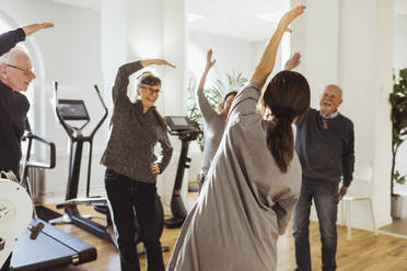 Pflegerin, die älteren Männern und Frauen im Pflegeheim beim Sport hilft - MASF29005