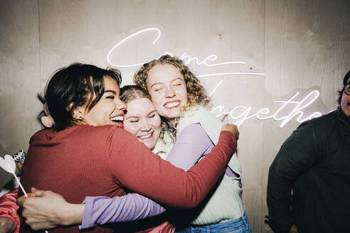 Glückliche multirassische Freundinnen umarmen sich im Studentenwohnheim - MASF29050