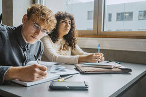 Junge gemischtrassige Studentinnen und Studenten lernen im Klassenzimmer eines Community College - MASF29124