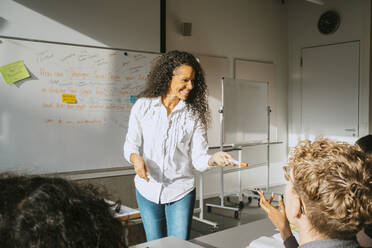 Smiling professor teaching university students in classroom - MASF29143