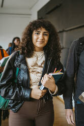 Portrait of smiling young woman walking with man at university - MASF29211