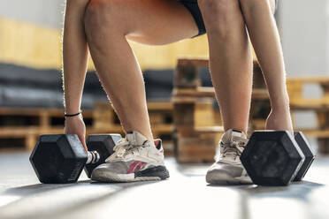 Athlete exercising with dumbbells in gym - JSRF01929