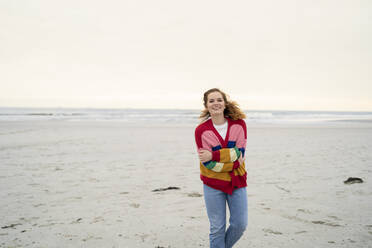 Happy young woman enjoying weekend at beach - AKLF00550