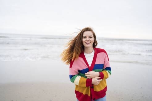 Cheerful redhead woman enjoying at beach - AKLF00559