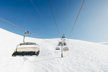 Seilbahnen auf einem schneebedeckten Berg an einem sonnigen Tag - OMIF00729