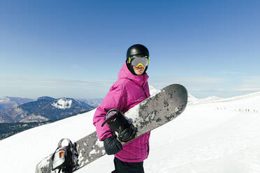 Man with snowboard on snowcapped mountain - OMIF00738