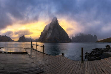 Hölzerne Kai sah auf ruhigen Wasser des Sees in der Nähe von Bergen in nebligen Wetter bei Sonnenaufgang in Lofoten Inseln in Norwegen - ADSF33911