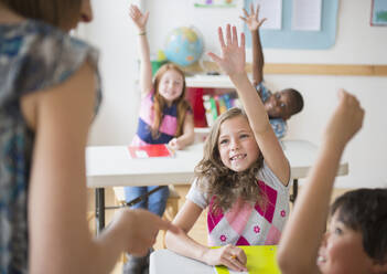 Kinder (8-9) heben die Hände im Klassenzimmer - TETF01274