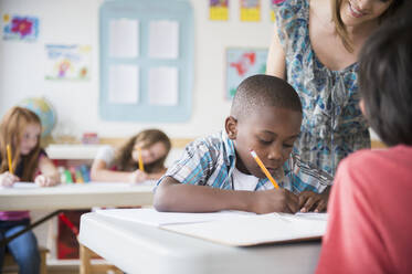 Children (8-9) with female teacher learning in classroom - TETF01275