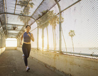 Woman jogging near beach at sunset - TETF01301