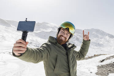 Smiling young man taking selfie through mobile phone - JRVF02852