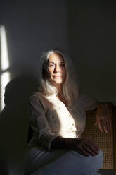 Woman with sunlight on her sitting at home - VEGF05413