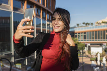 Lächelnde Geschäftsfrau nimmt Selfie durch Smartphone - JRVF02878