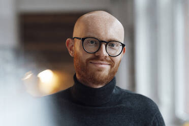 Lächelnder arbeitender Mann mit Brille im Büro - JOSEF07634