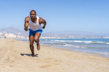 Sportler beim Laufen am Strand an einem sonnigen Tag - DLTSF02808