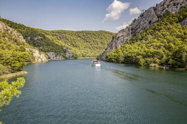 Im Fluss vertäutes Schiff inmitten der Berge, Nationalpark Krka, Sibenik-Knin, Kroatien - MAMF02016