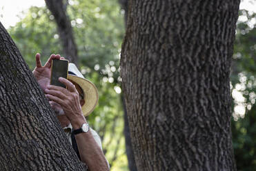 Elderly man taking picture through smart phone at Krka National Park, Sibenik-Knin, Croatia - MAMF02033