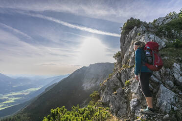 Female hiker admiring early sunset from summit of Aiplspitz mountain - FOF12971