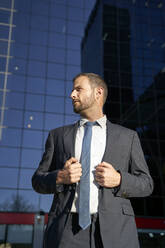 Businessman in suit standing on sunny day - VEGF05445