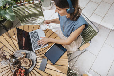 Working woman using laptop at tablet in back yard - MFF08751