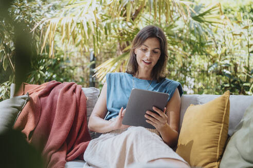 Geschäftsfrau mit Tablet-Computer auf dem Sofa sitzend - MFF08772