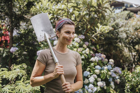 Lächelnder Gärtner mit Schaufel im Garten - MFF08811