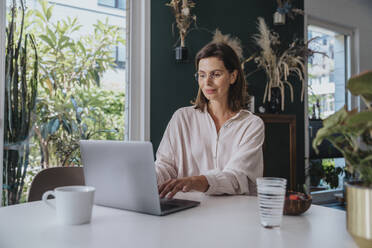 Freelancer working on laptop at home office - MFF08825