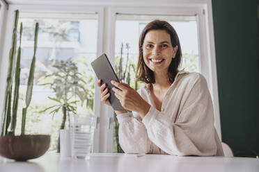 Frau mit Tablet-PC lächelnd zu Hause - MFF08832