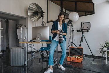 Fotograf mit Kamera im Studio stehend - MFF08848