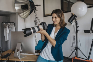 Fotograf, der durch die Kamera im Studio fotografiert - MFF08850