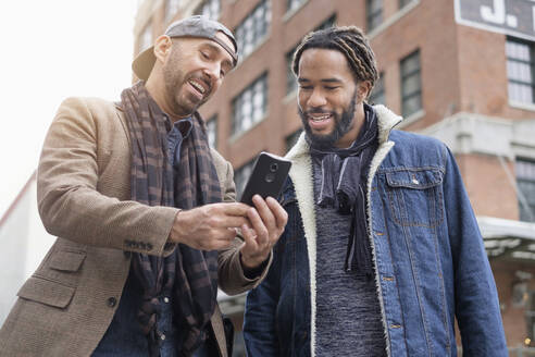 Smiley homosexuelles Paar nimmt Selfie mit Smartphone in Straße - TETF01445