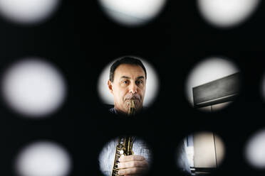 Musiker spielt Saxophon durch Notenständer gesehen - JRFF05327