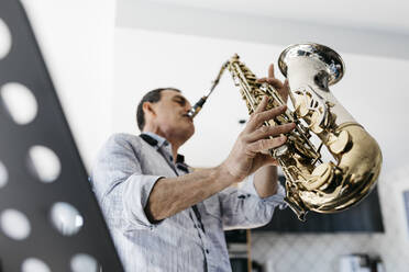 Saxophonist spielt Saxophon und übt zu Hause - JRFF05339