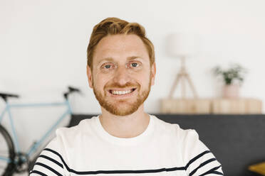 Happy young man with red hair at home - XLGF02884