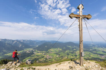Wanderin bewundert Aussicht vom Bockstein mit Gipfelkreuz im Vordergrund - FOF12995