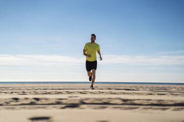 Sportler joggt am Strand an einem sonnigen Tag - DIGF17723