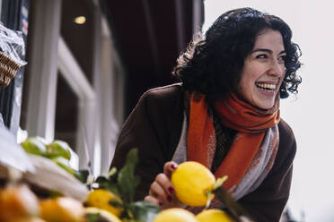 Glückliche junge Frau kauft Früchte auf dem Markt - AMWF00203