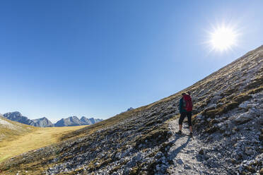 Sun shining over female hiker admiring surrounding landscape on way to Brunnensteinspitze - FOF12999