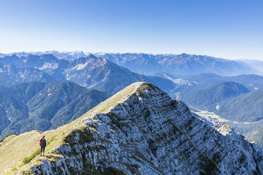 Female hiker admiring surrounding landscape from mountaintop - FOF13004