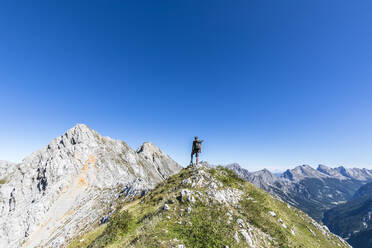 Male hiker admiring view of Mittenwalder Hohenweg in summer - FOF13017