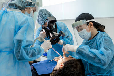 Chirurg mit Krankenschwestern, die einen Patienten im Operationssaal eines Krankenhauses operieren - DLTSF02846