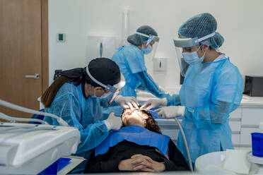 Surgeon with nurses doing surgery of patient in operating room at hospital - DLTSF02847