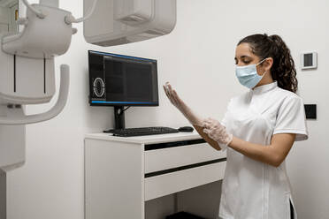 Nurse wearing protective glove in laboratory at maxillofacial clinic - DLTSF02862