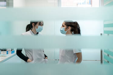 Nurses in protective face masks discussing at maxillofacial clinic - DLTSF02868