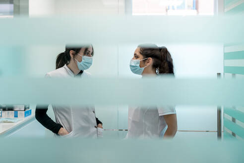 Krankenschwestern mit Gesichtsschutzmasken diskutieren in der Kieferklinik - DLTSF02868