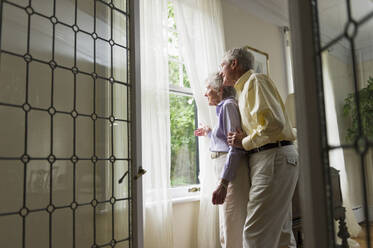 Senior couple looking through window - TETF01477
