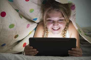 Girl (12-13) using tablet in bed - TETF01493