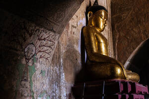 Skulptur des alten Buddha auf einem Ständer an der schäbigen Steinwand des berühmten traditionellen Thatbyinnyu-Tempels in Bagan in Myanmar - ADSF34055