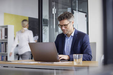 Geschäftsmann arbeitet am Laptop im Büro - RBF08703